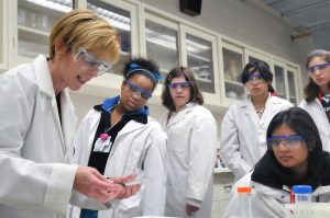 Five diverse women in a science laboratory